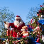 santa claus riding on red and blue cart