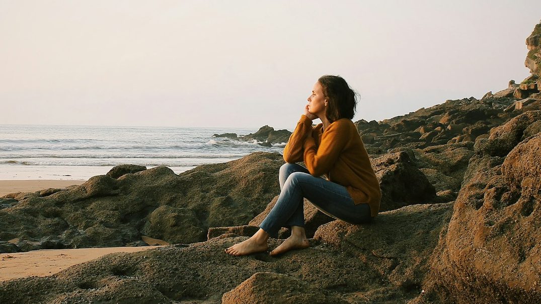 woman sitting near sea during daytime. 7 Unstoppable Ways to Boost Your Self-Esteem