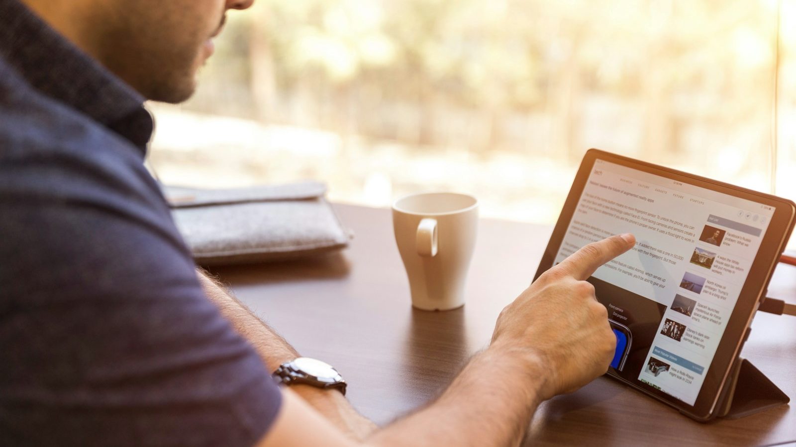 man holding tablet computer. 7 Best Ways to Improve Your LinkedIn Profile