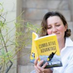 woman in white dress shirt holding yellow book