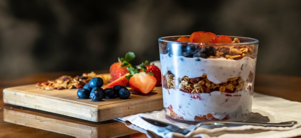 strawberries and cookies with cream filled dessert in glass cup