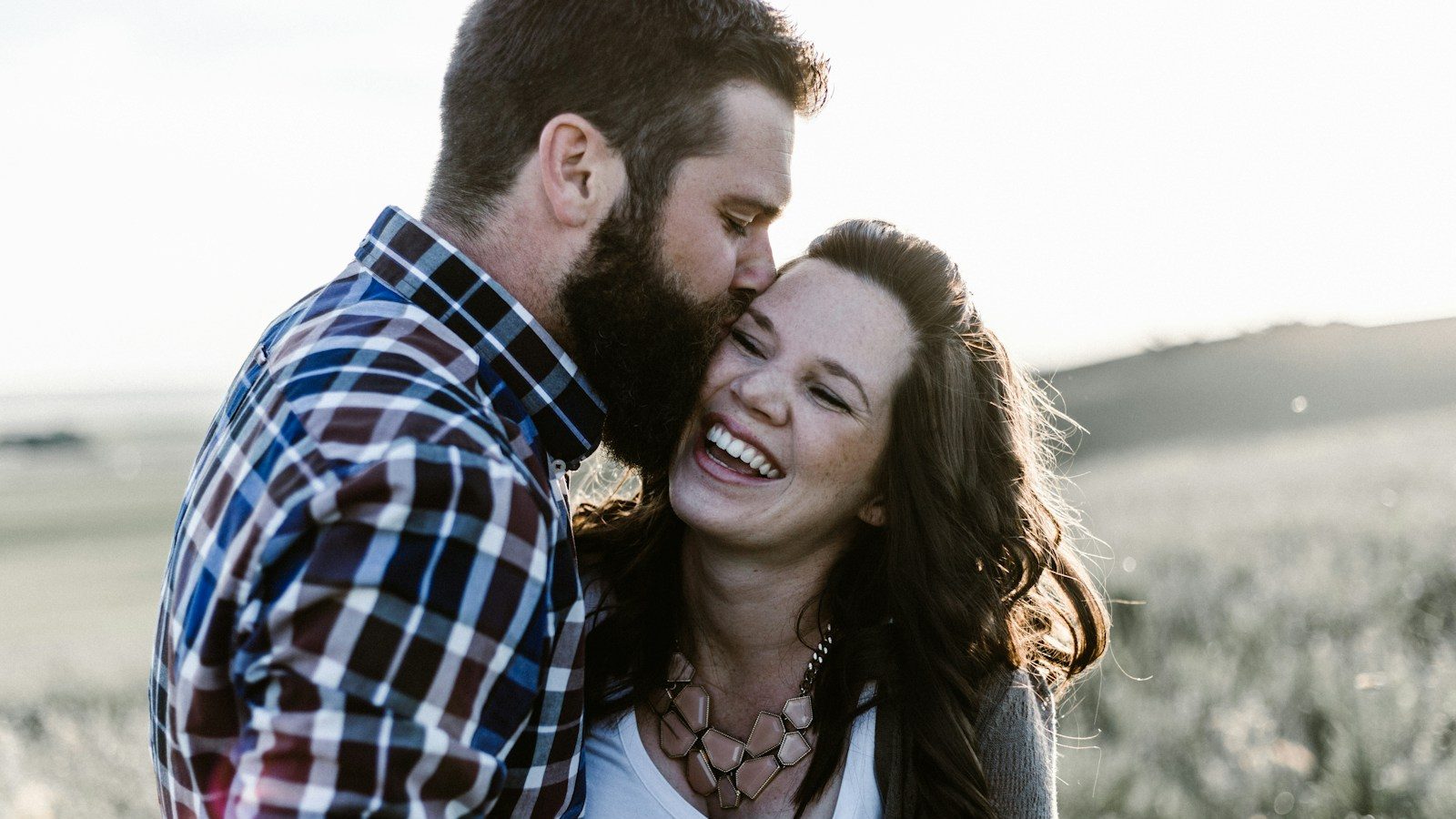 man kissing woman in grass area. 10 Simple Habits to Build Stronger Relationships