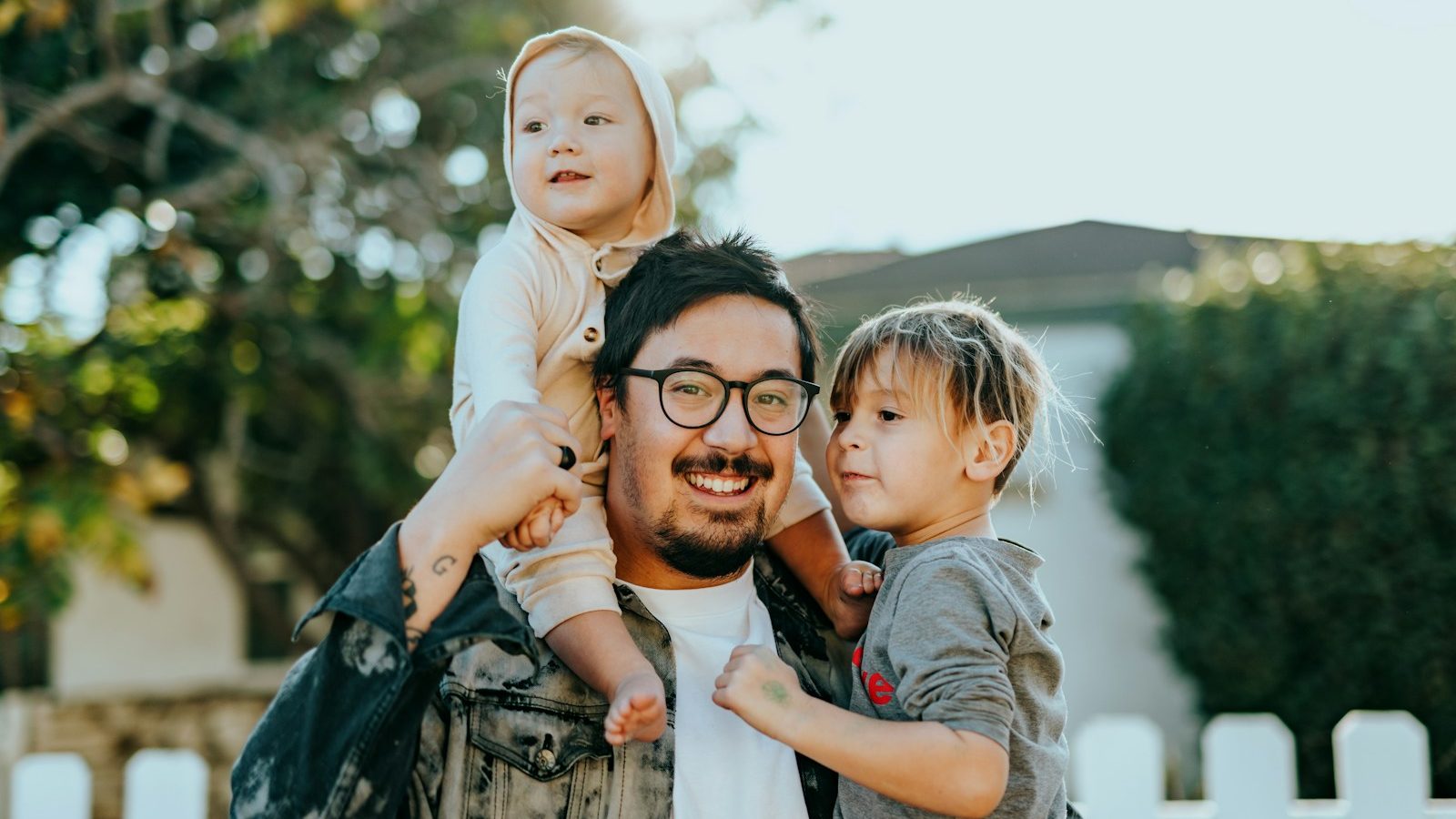 man in white shirt carrying girl in gray shirt. 10 Powerful Ways to Teach Your Kids About Money