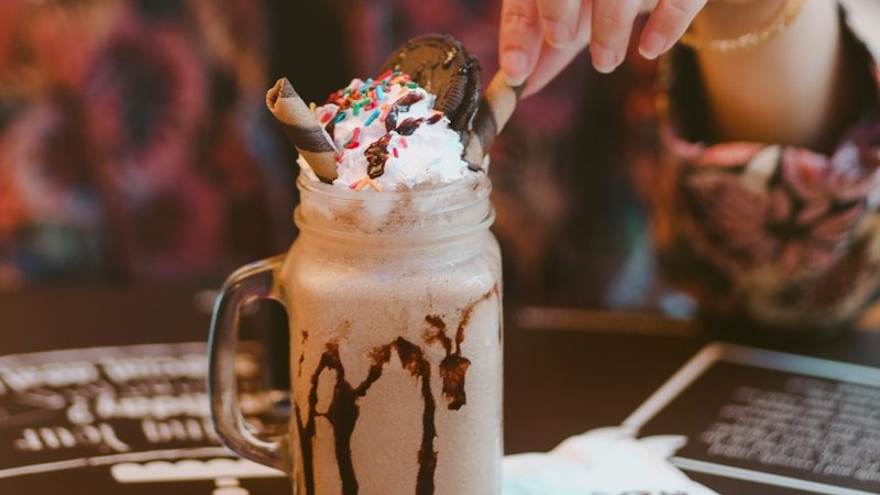 a woman wearing a red bandana eating a chocolate milkshake. 5 Worst Fast Foods You Should Never Eat Again