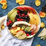 bowl of sliced fruits on white textile