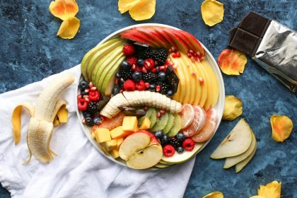 bowl of sliced fruits on white textile