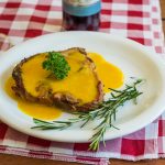 Cooked pork chop on round white ceramic plate