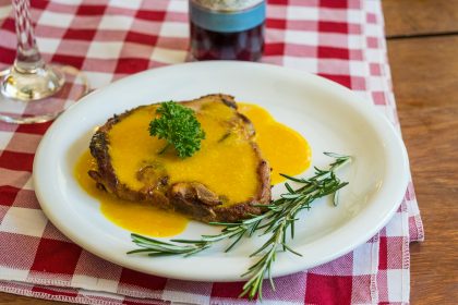 Cooked pork chop on round white ceramic plate