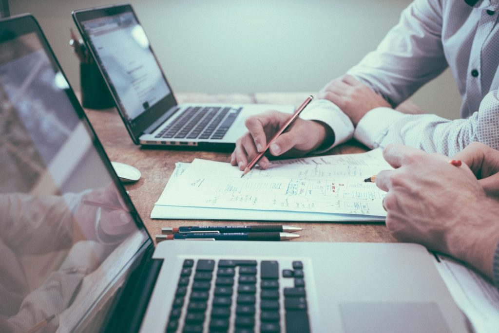 person holding pencil near laptop computer, 6 Critical Steps to Grow Your Side Hustle in 2024