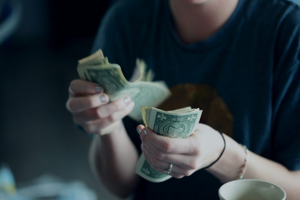 focus photography of person counting dollar banknotes, 7 Terrible Money Habits You Need to Break Now