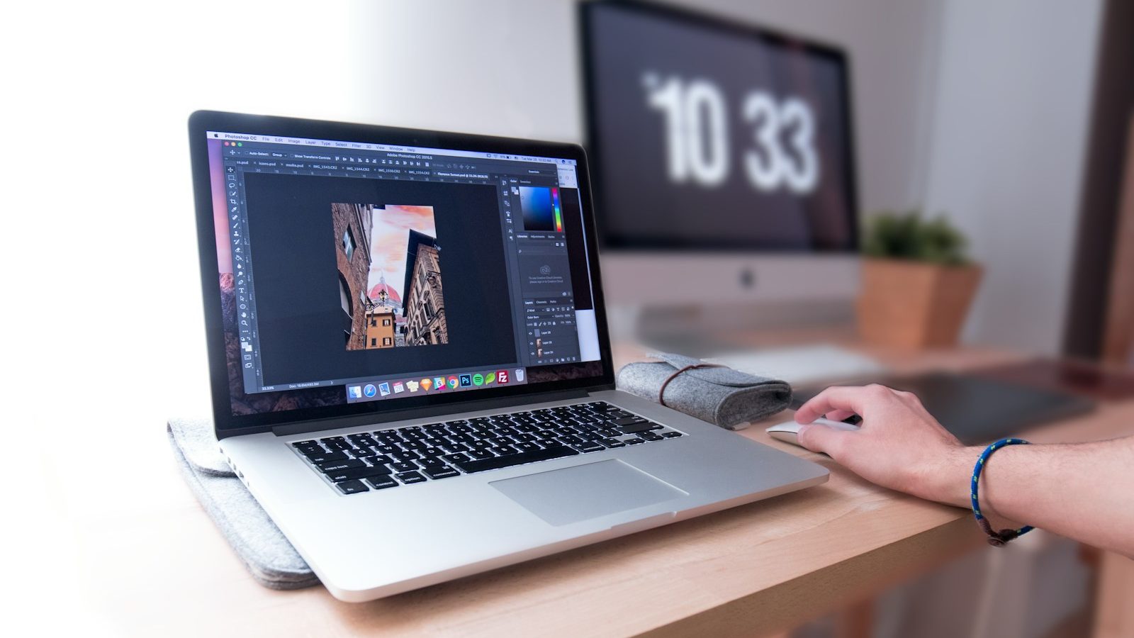 person using MacBook Pro on brown wooden desk