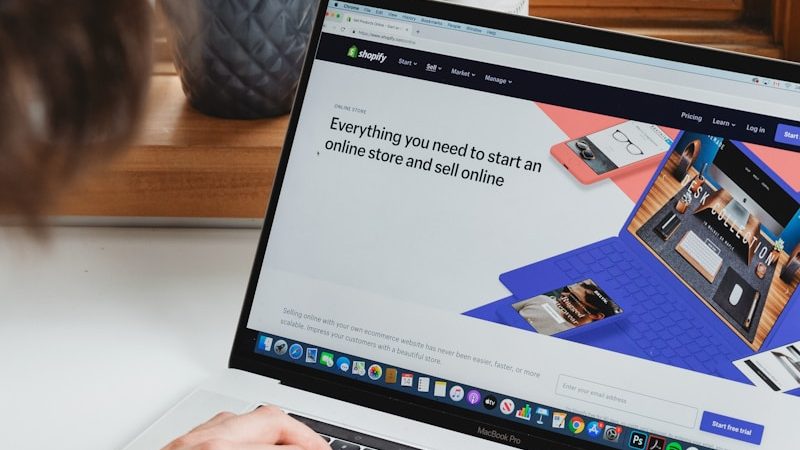 person using macbook pro on white table, Top 10 Essential Tools for Shopify App Developers: Streamline Your Development Process