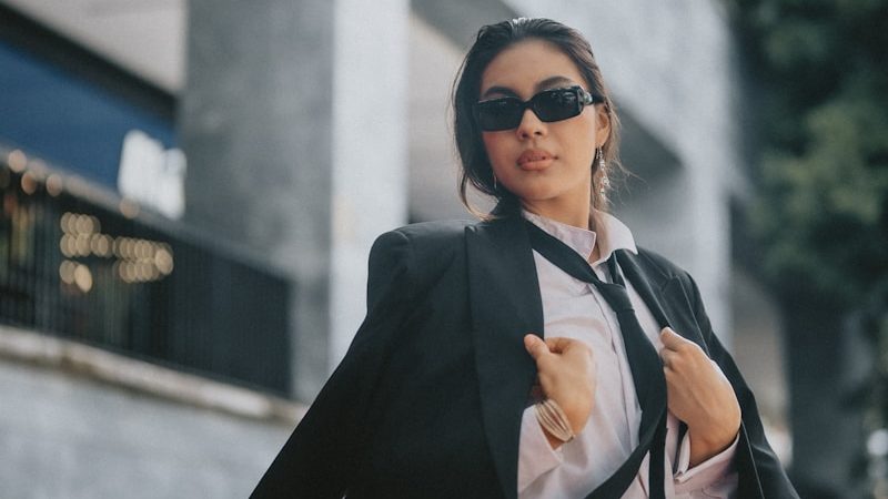 A woman in a suit and sunglasses is walking down the street, 10 Power Outfits That Will Boost Your Confidence