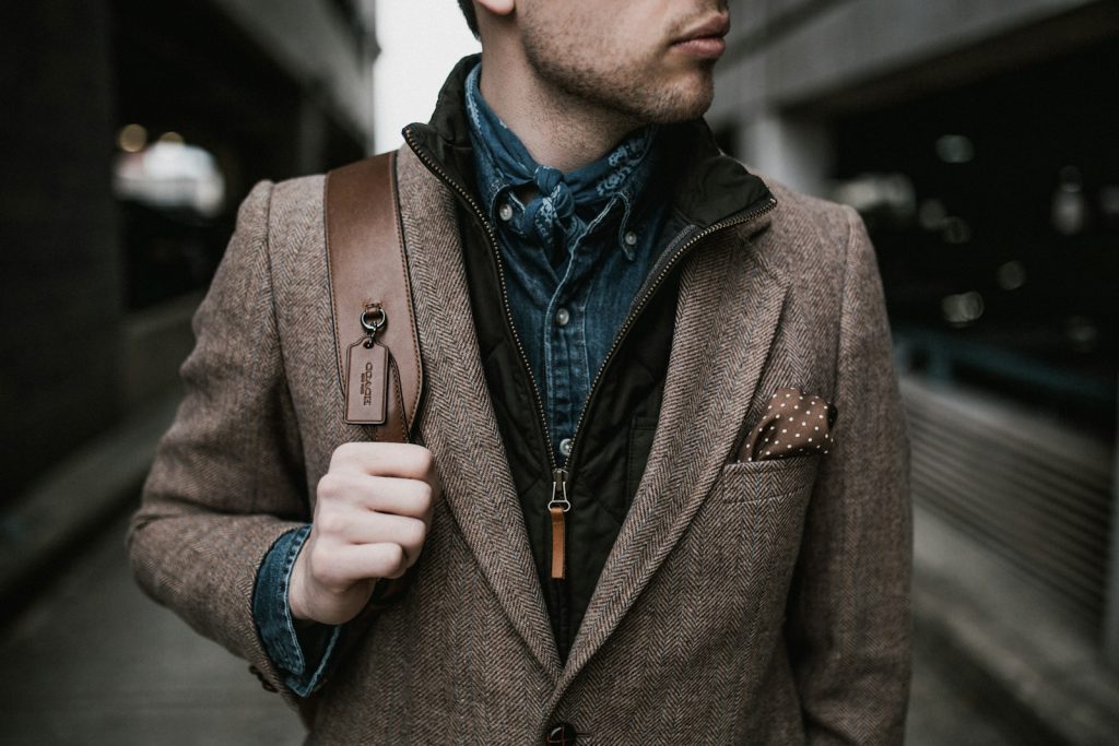 man in brown suit jacket carrying brown backpack, 7 Awful Fashion Mistakes That Make You Look Older