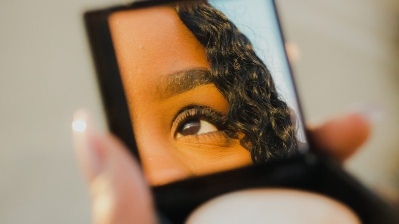 a woman holding a compact 10 Best Makeup Products You Need in Your Collection