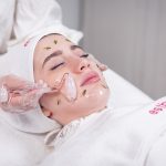 a woman getting a facial mask on her face