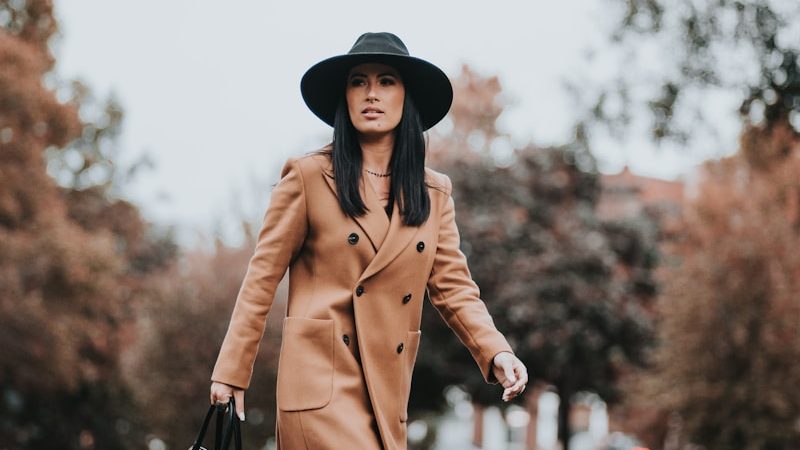 woman in brown coat holding black leather handbag, 10 Power Outfits That Will Boost Your Confidence