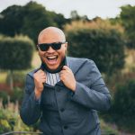 man in gray suit jacket wearing black sunglasses