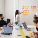 woman placing sticky notes on wall How to Use Influencer Marketing to Boost Your Brand