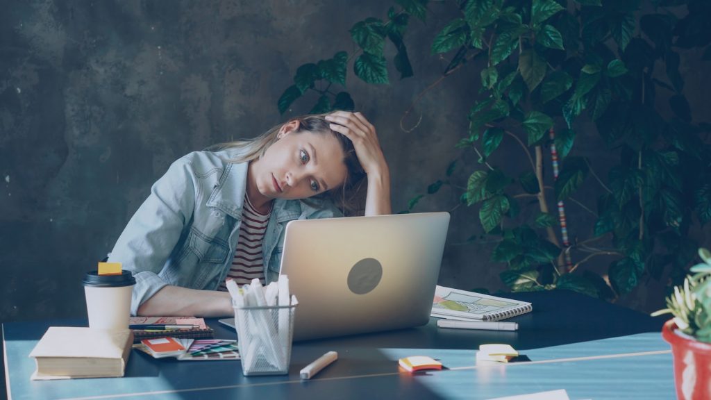 A woman appears stressed while working on laptop. Monetary Efficiency Valuing Time Over Money