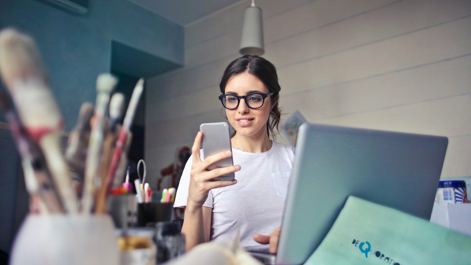 woman in white shirt using smartphone Influencers Crowdfunding Campaigns