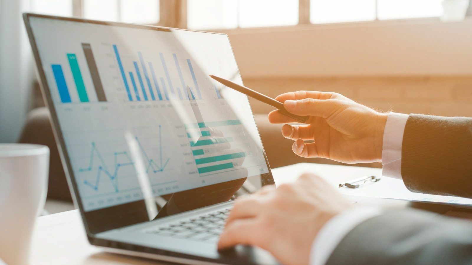 person analyzing business charts on laptop Financial Strategy Financial Mistakes