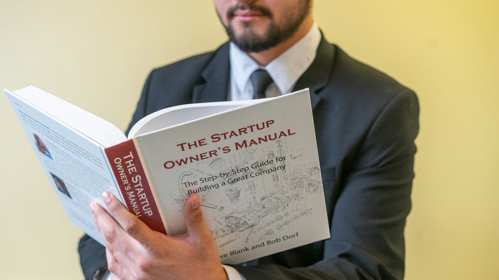 a man in a suit is reading a book Balancing Stability Creating Multiple Revenue Streams