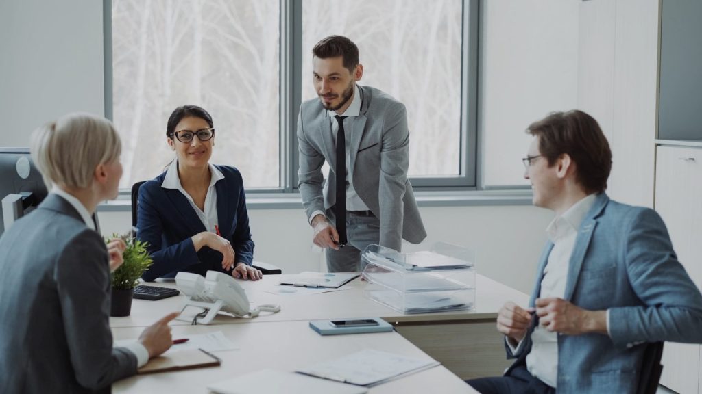 Business professionals collaborating around a conference table. Explaining Compensation Talking Money With Your Team