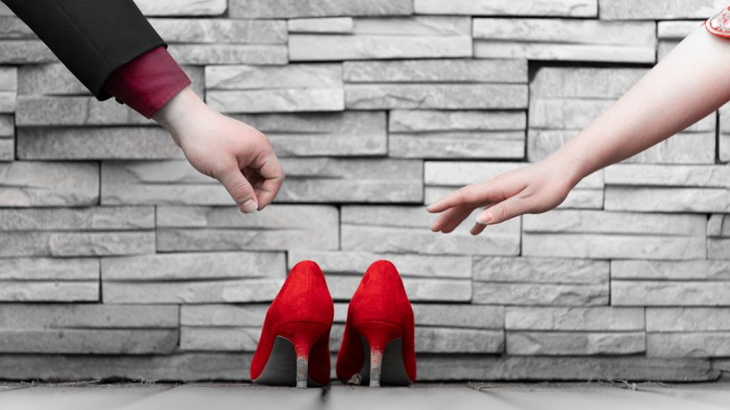 a pair of hands reaching for a pair of red high heels Handle Objections Optimizing Product Descriptions