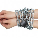 Social theme: hands tied a metal chain on a white background