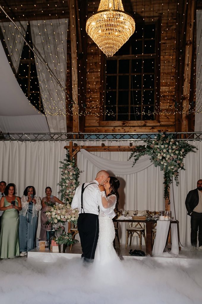 First dance under en kristallkrona på Lekhuset i Floda, där brudparet delar ett romantiskt ögonblick på dansgolvet.