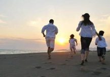 Billede af stressfri familie der løber på strand