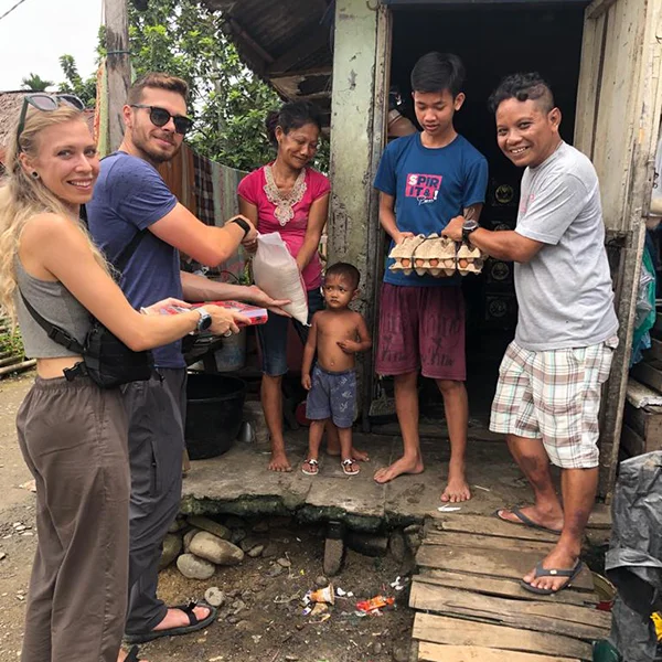 Tourists from Sumatra Orangutan Trekking donating food to a single mother with two kids