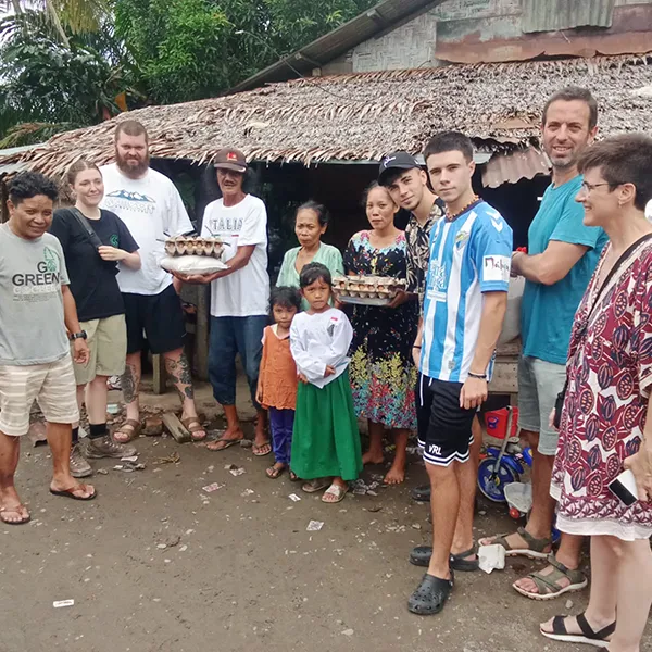 Big Tourist family from Sumatra Orangutan Trekking donating eggs and rice to an indonesian family