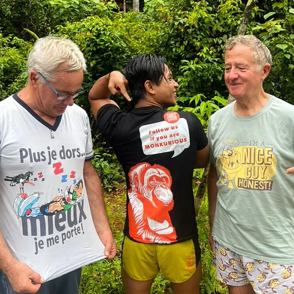Three hikers in playful shirts standing together in the jungle, showcasing their adventure spirit with humorous and light-hearted messages.