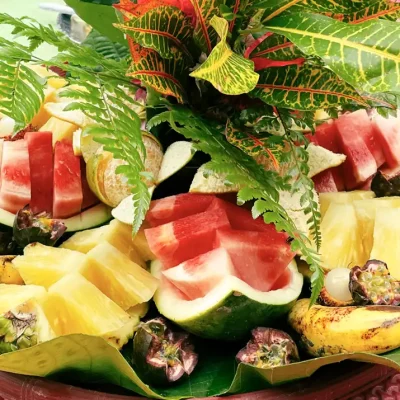 Some delicious watermelon and pineapple sliced og decorated in a beautiful way with palm leaves