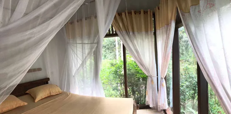 a bed in a hotel with view to the beautiful nature