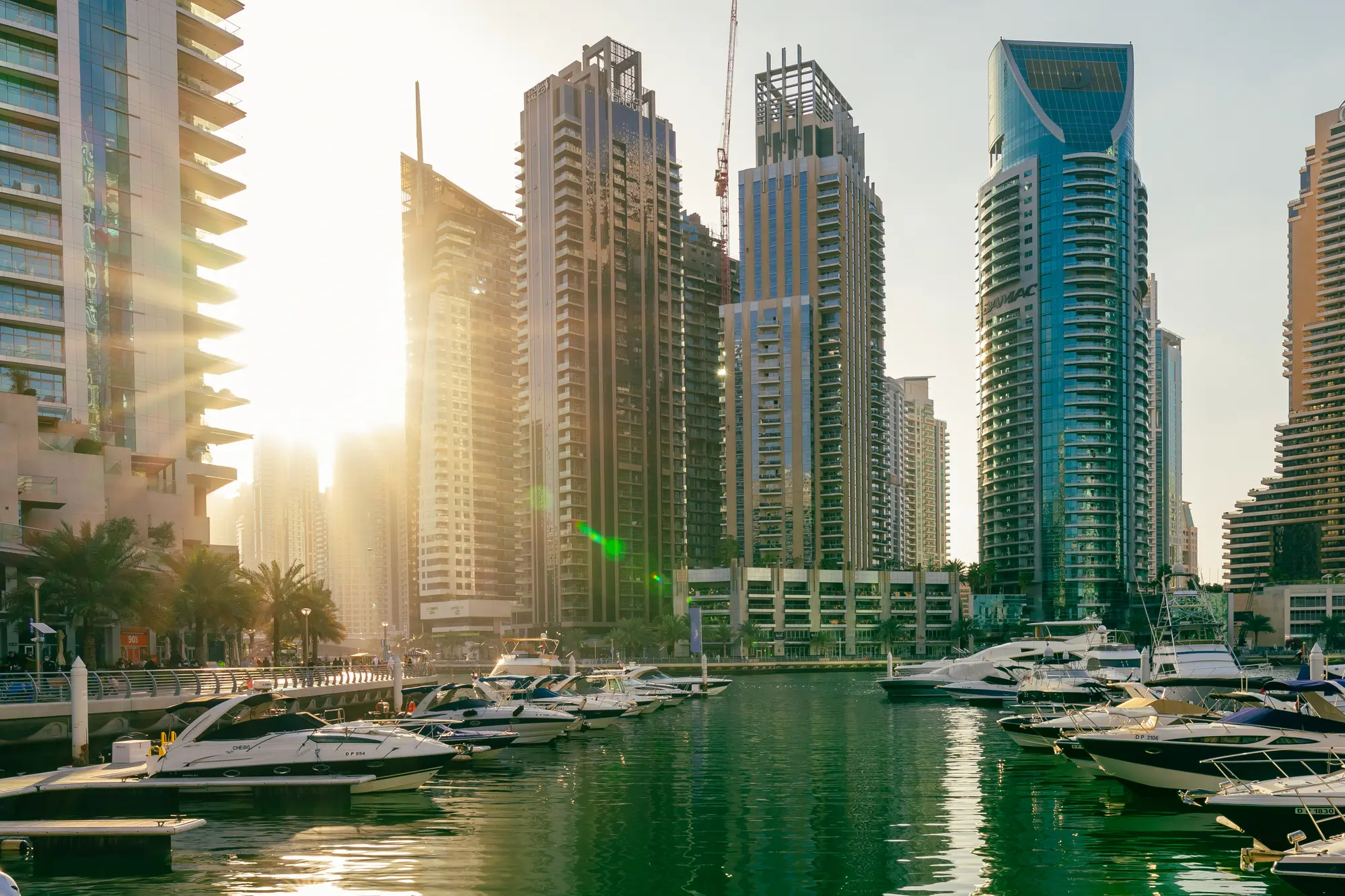 Sunset over Dubai Marina with boats and skyscrapers in the background at sunset, a must during your 2 days in Dubai.