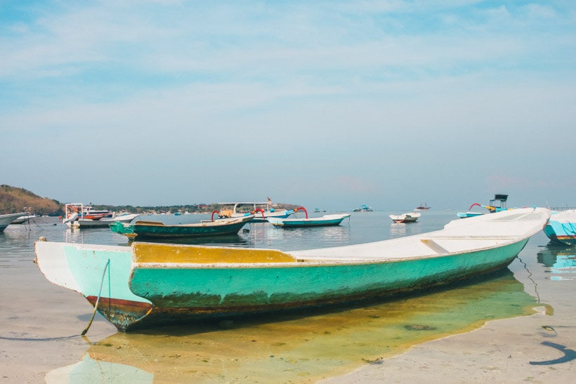 Yellow and turquoise traditional boat on Nusa Lembongan - How to get around.