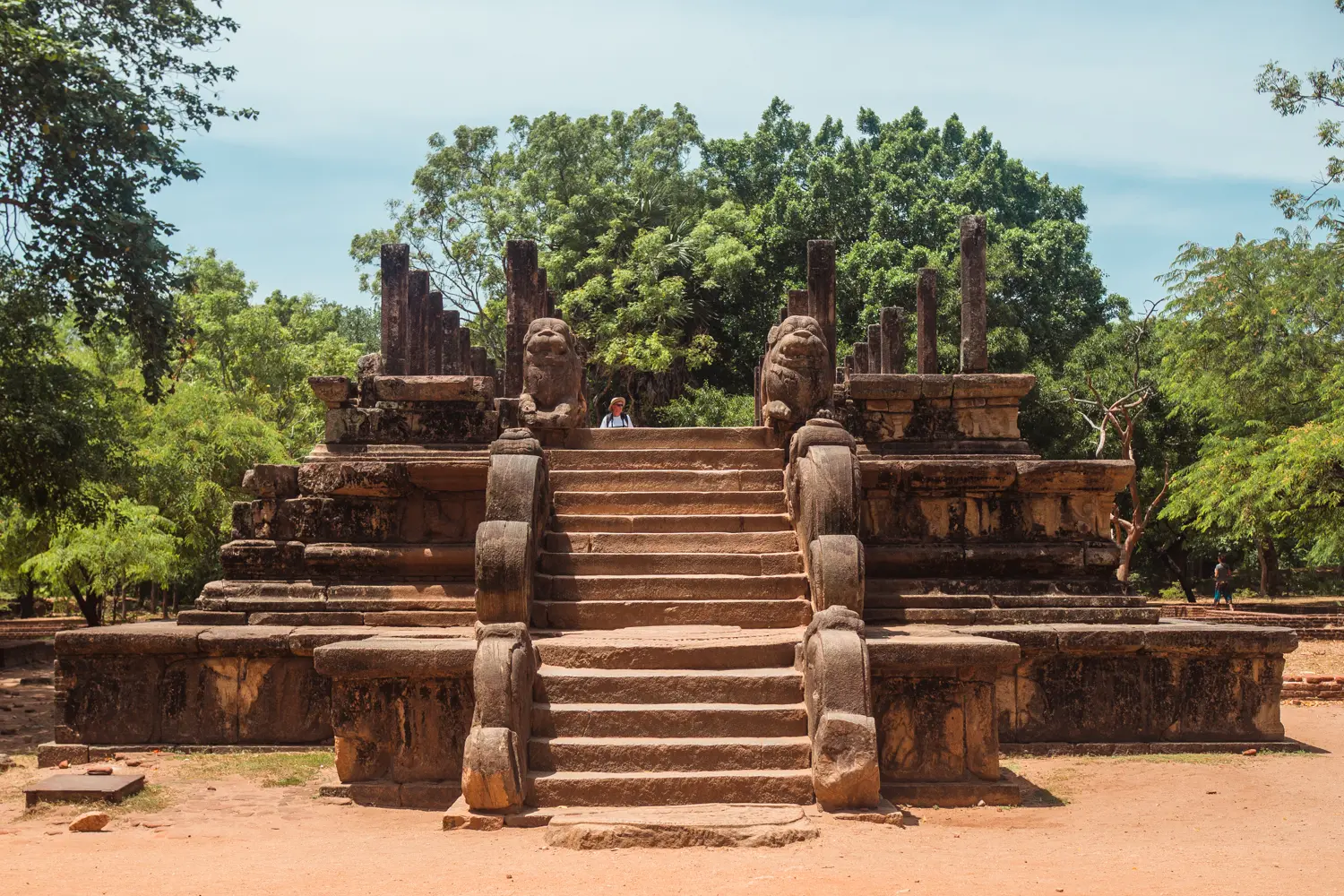 The audience hall, or council chambers, in Polonnaruwa with stairs leading up to two stone lions on a brick foundations with pillars.