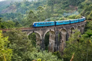 Blue train running over the Nine Arches stone bridge in the jungle of Ella, a must on any 2-week Sri Lanka itinerary.