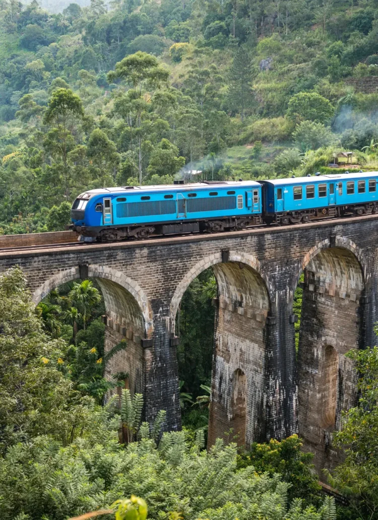 Blue train running over the Nine Arches stone bridge in the jungle of Ella, a must on any 2-week Sri Lanka itinerary.