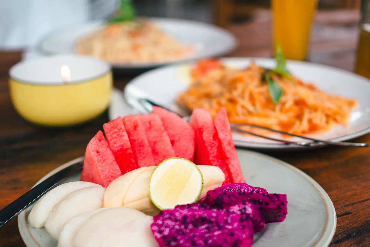 Pink Dragonfruit, watermelon and banana on a plate with fried noodles in the background, is Nusa Penida worth visiting?