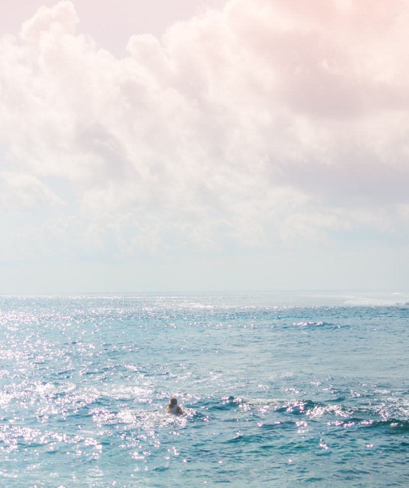 Surfer paddling out from Green Bowl Beach during sunrise, one of the best beaches in Uluwatu Bali.