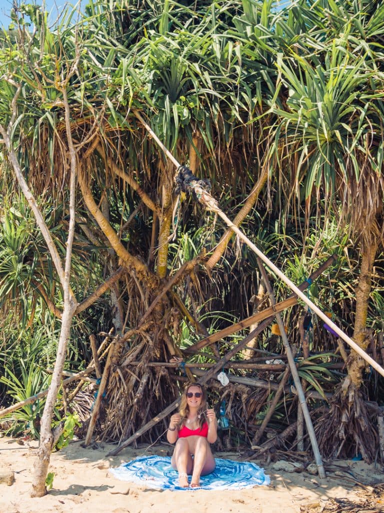 Girl sitting in the shade under trees at Nyang Nyang Beach, one of the best beaches in Uluwatu.