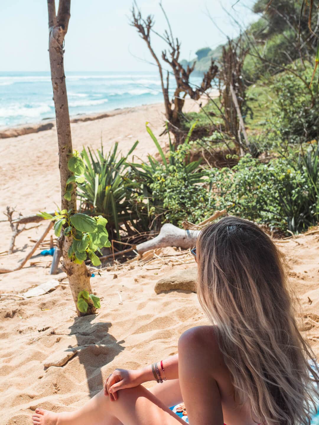 Girl chilling in the shade on Nyang Nyang Beach in Uluwatu, Bali.