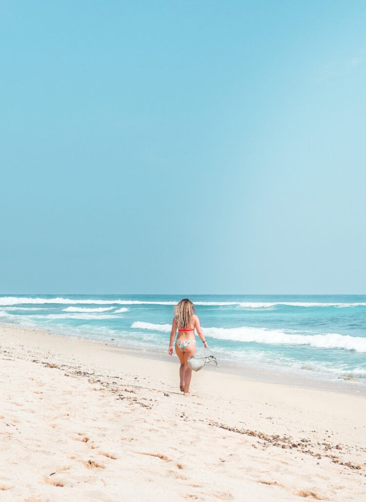 Girl walking along Nyang Nyang Beach in Uluwatu on a sunny day