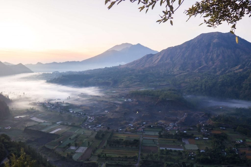 Sunrise over Pinggan Village in Bali, white mist covering the village between the volcanos North in Bali