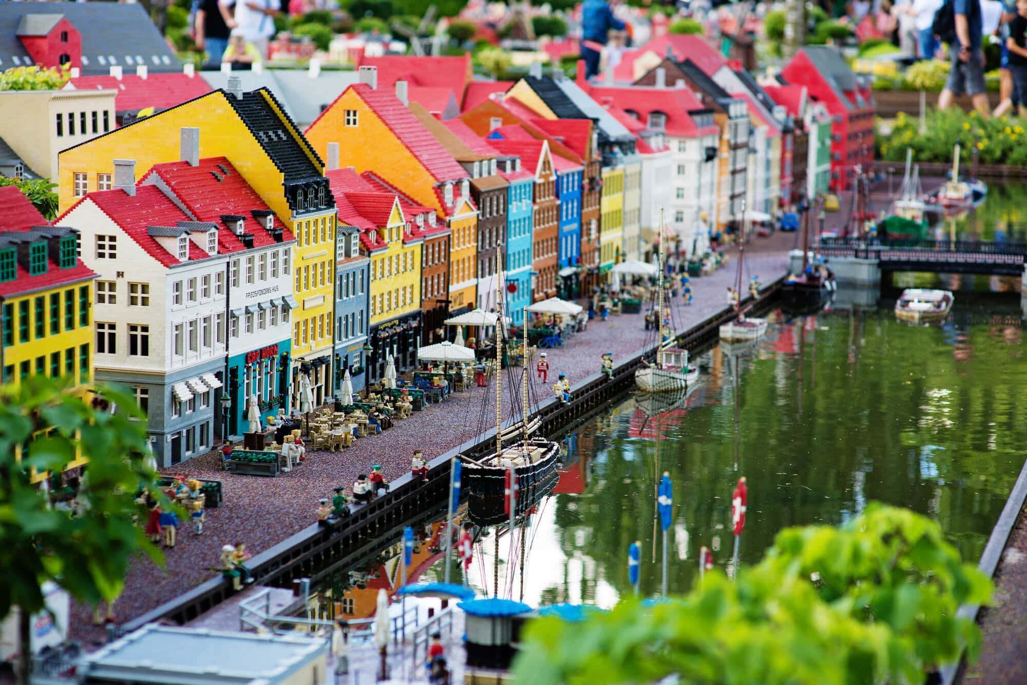 A realistic looking lego scene with a colorful line of houses along a harbor with boats in Legoland in Billund, the perfect day trip from Aarhus.