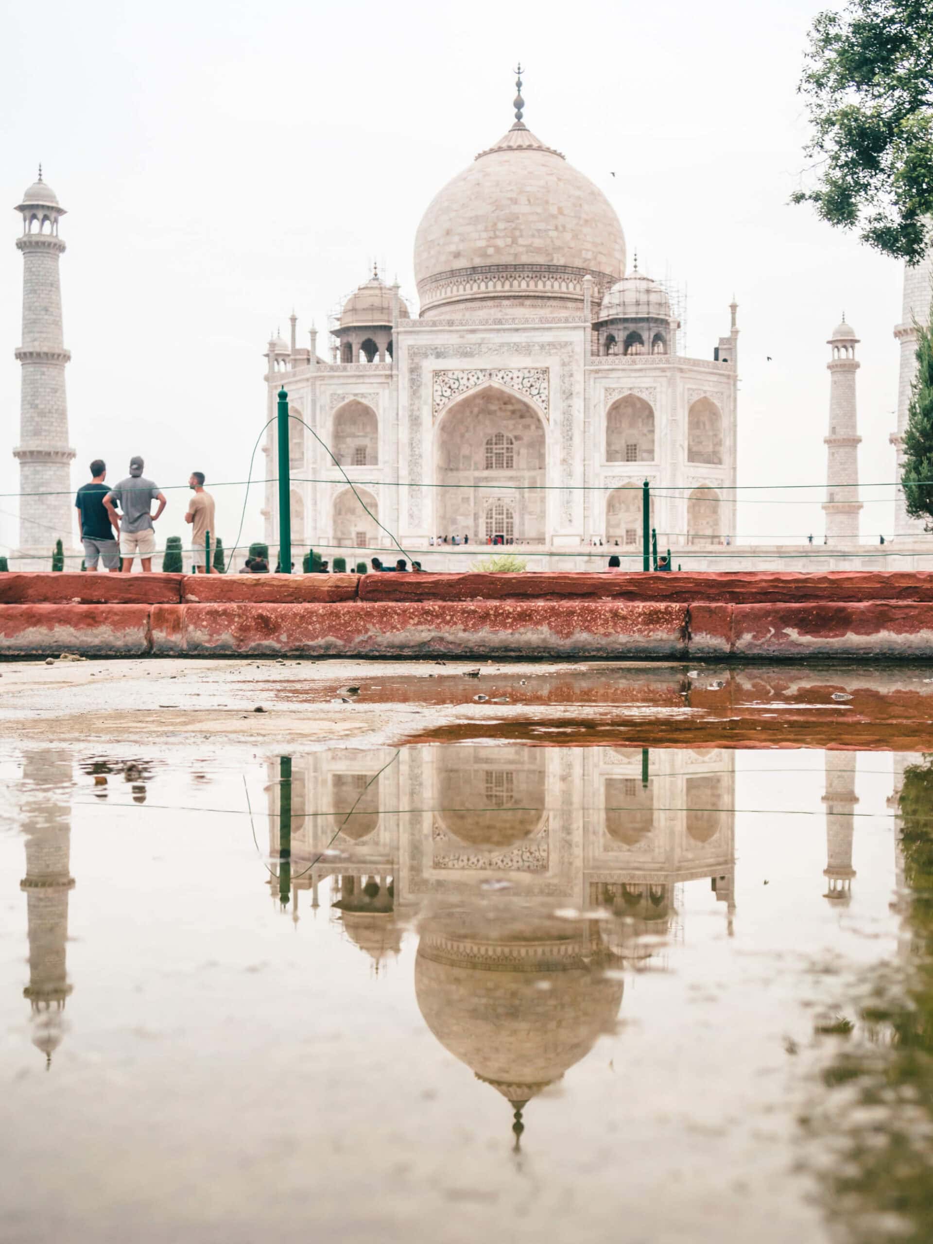 The white Taj Mahal with one big dome and one small on each side, reflection in a little puddle, Taj Mahal photography tips.